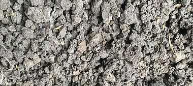 Bodenstruktur mit sichtbaren Aggregaten und organischem Material.