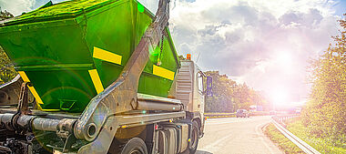 Lastkraftwagen fährt auf einer Landstraße mit Blick auf eine grüne Landschaft.