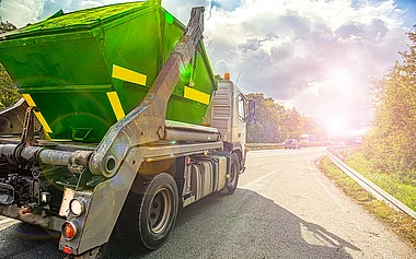 Lastkraftwagen fährt auf einer Landstraße mit Blick auf eine grüne Landschaft.